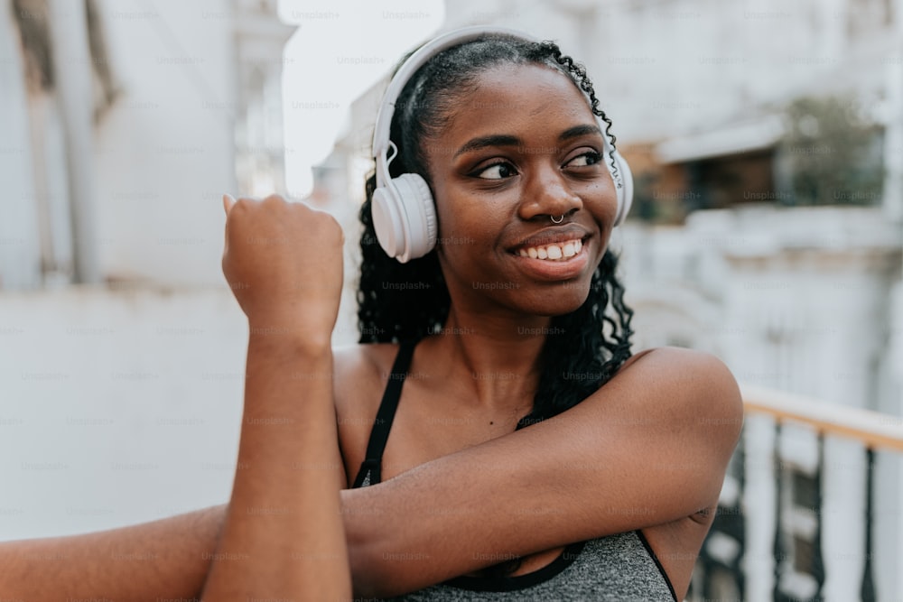 a woman wearing headphones and smiling at the camera