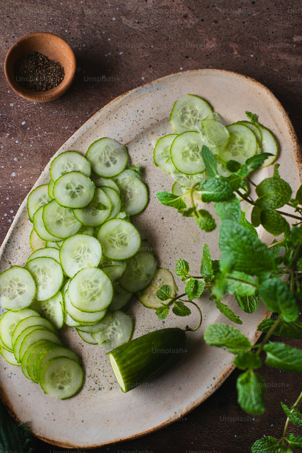 a plate of cucumbers and mints on a table