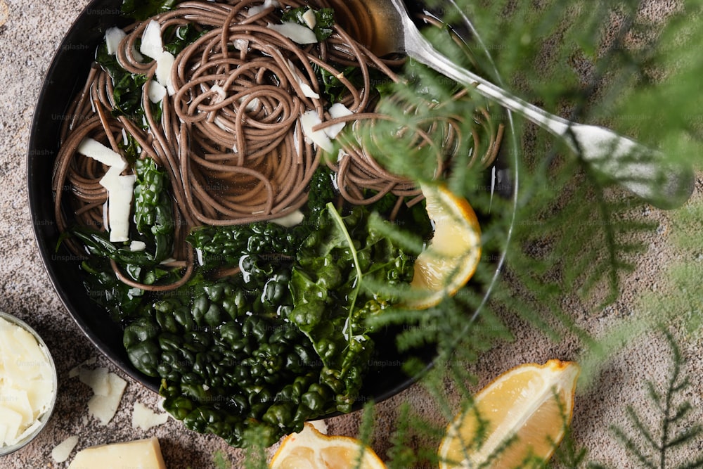 a pan filled with pasta and greens on top of a table