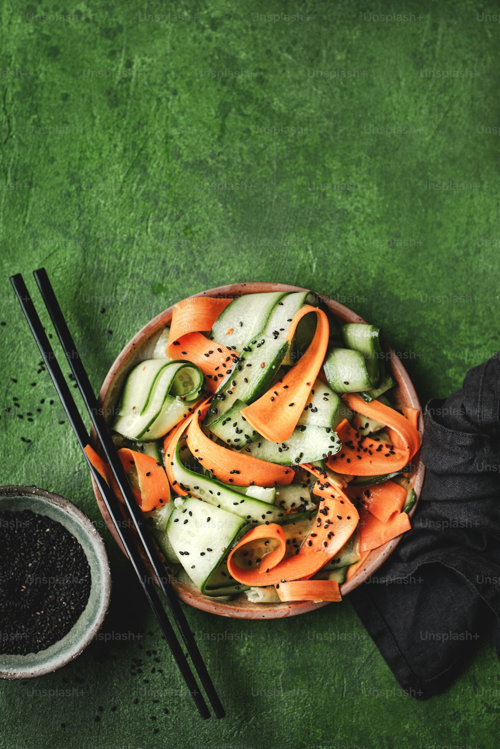 緑色の表面に箸で野菜のボウル