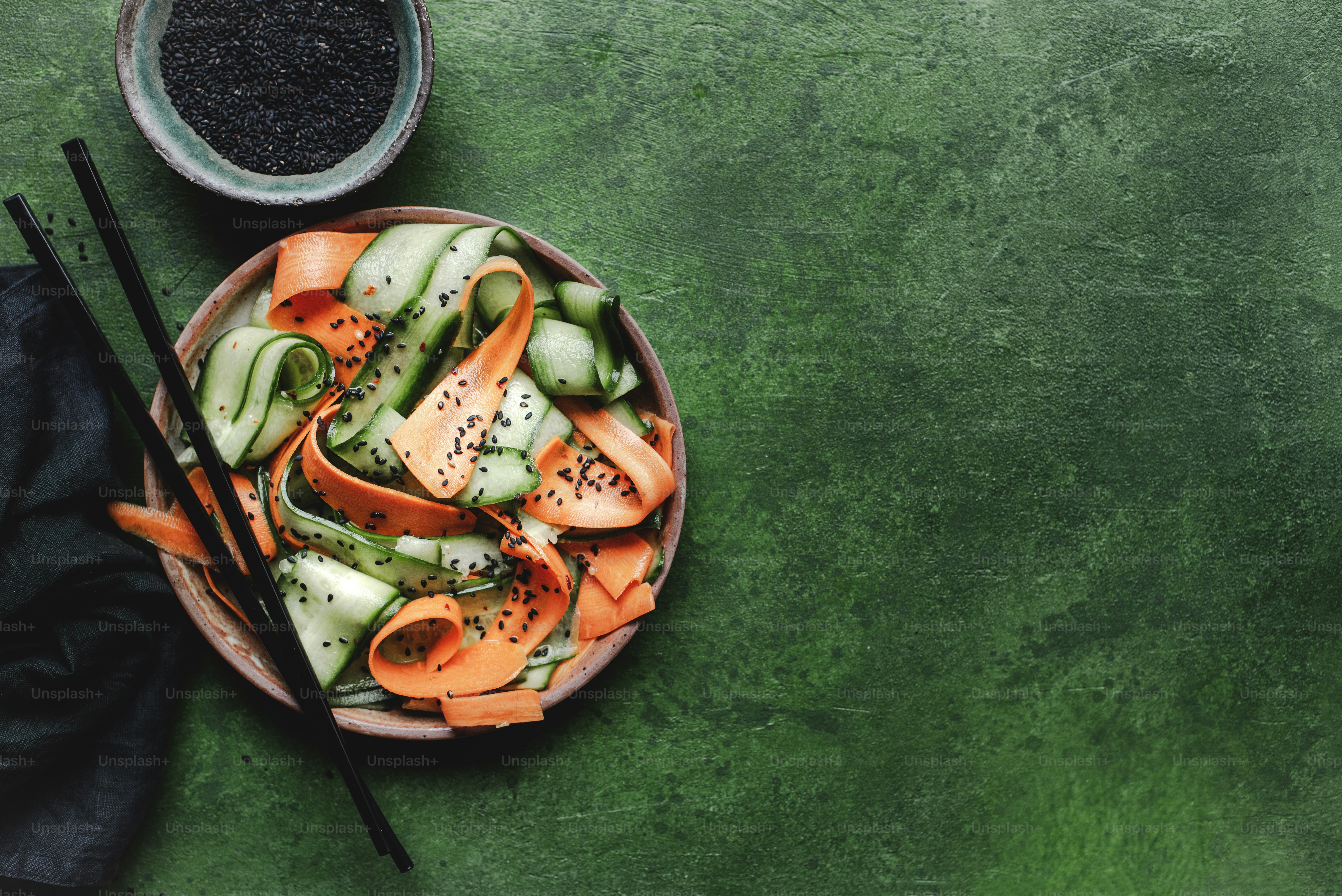緑色の表面に箸で野菜のボウル