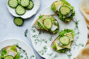 a white plate topped with cucumber sandwiches on top of a table