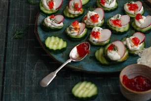 a plate of cucumbers with sauce and a spoon