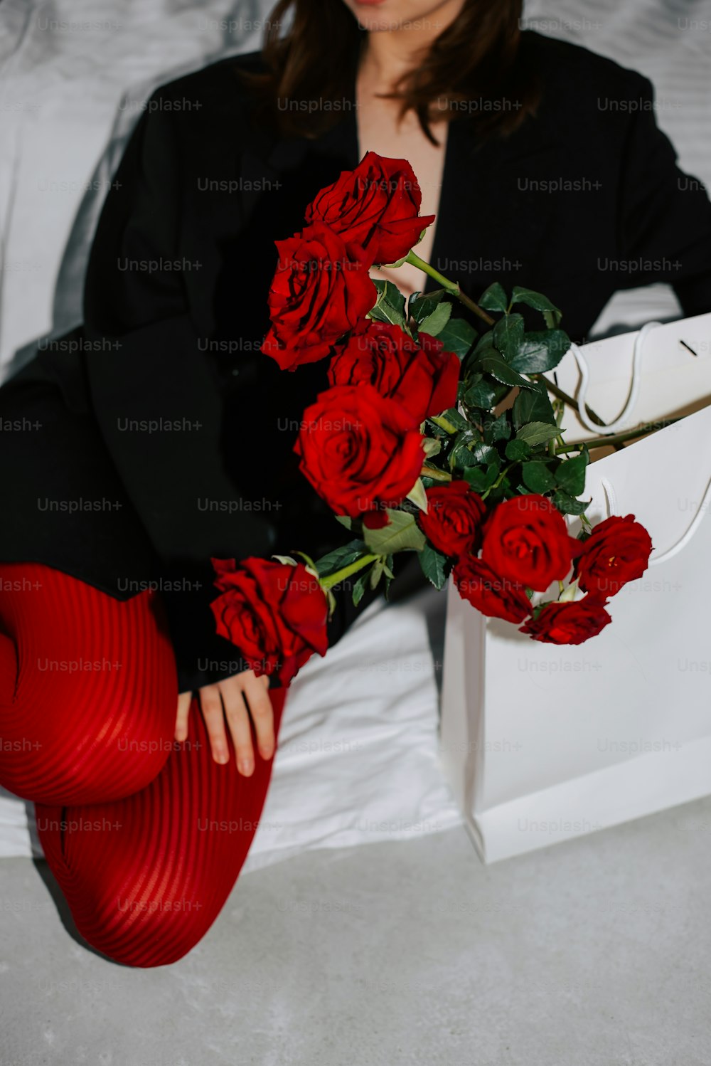 a woman in red stockings holding a bouquet of roses