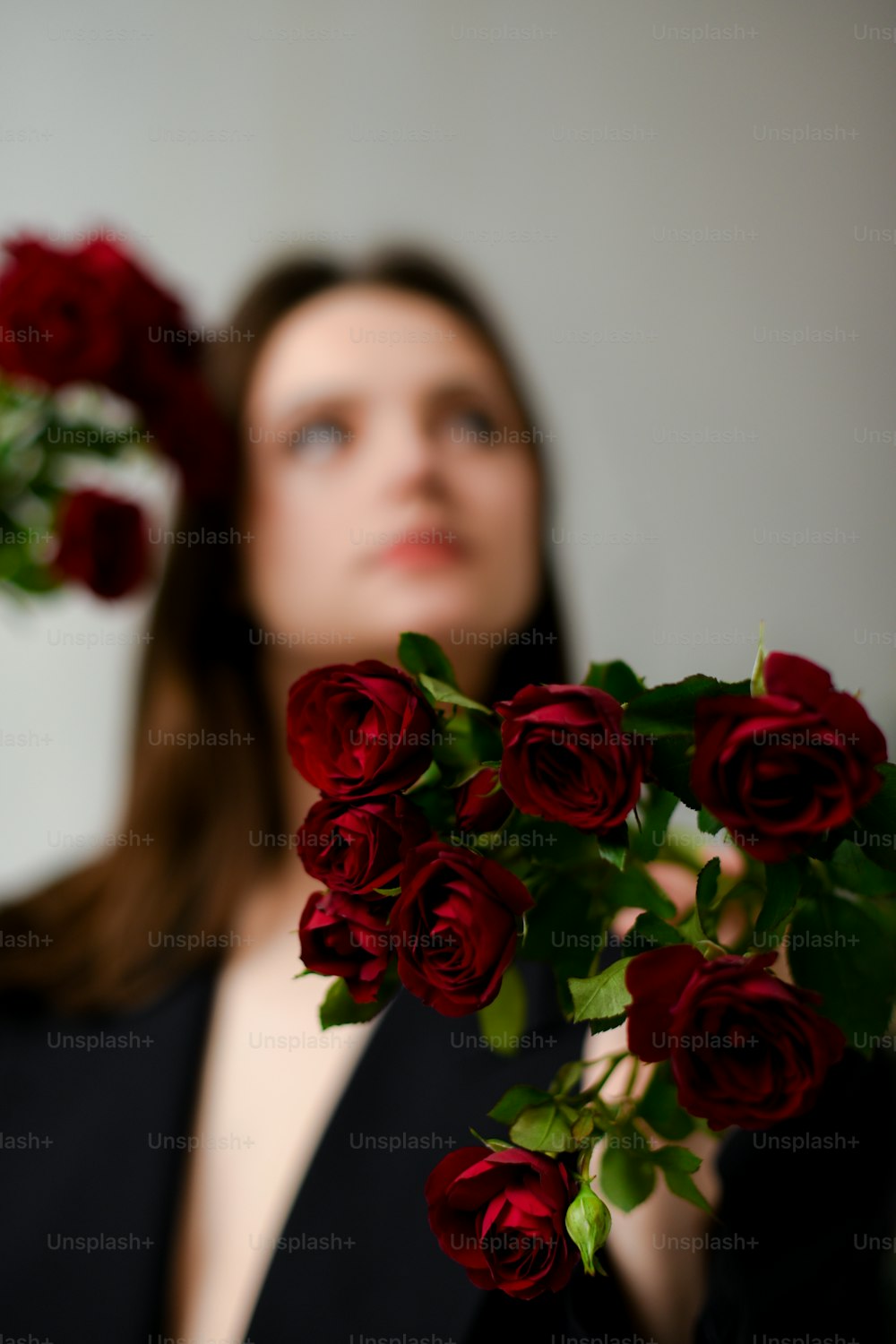 une femme tenant un bouquet de roses devant son visage