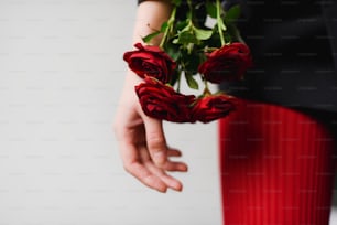 une personne tenant un bouquet de roses dans ses mains