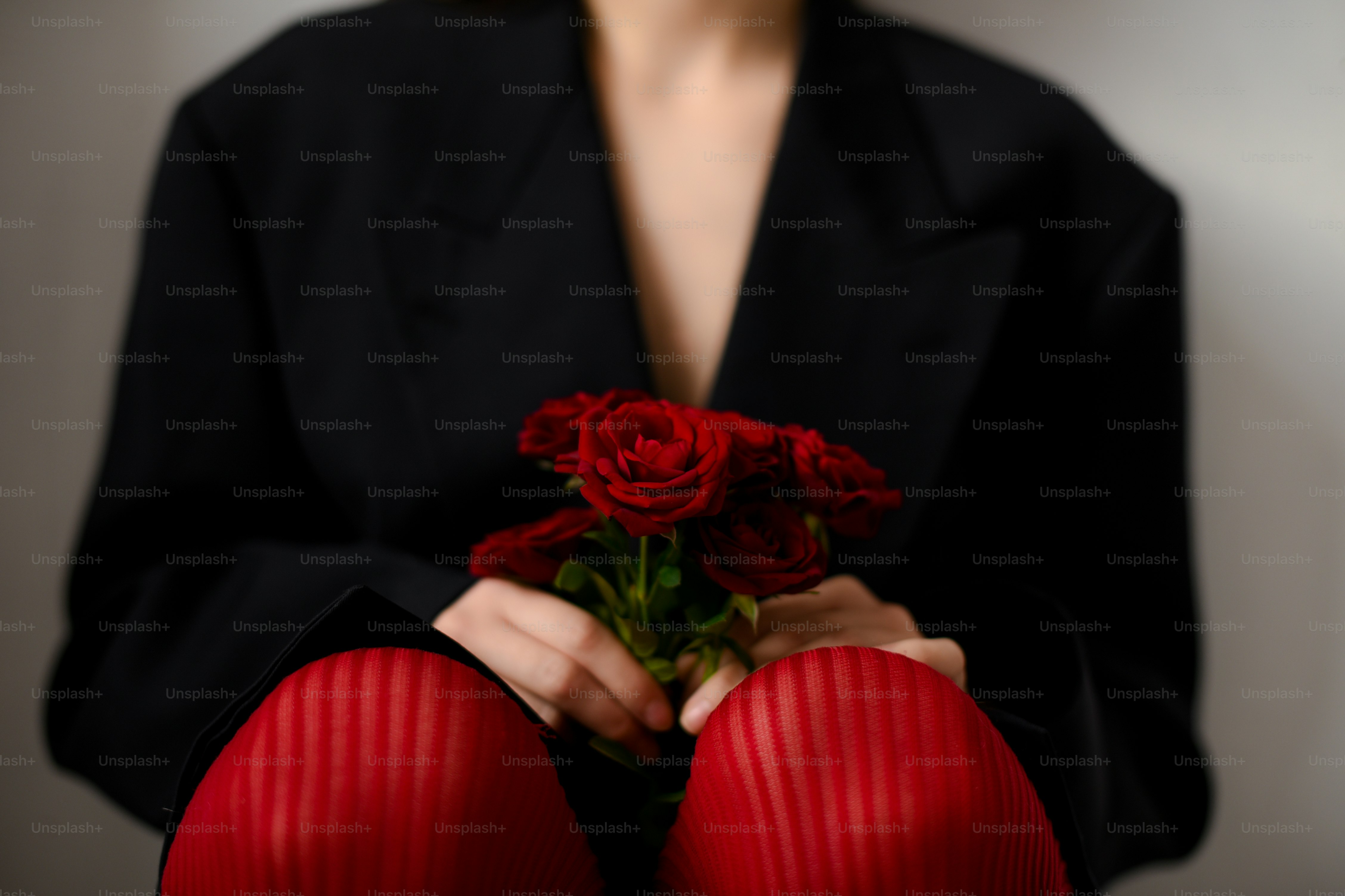 赤いバラの花束を持つ女性