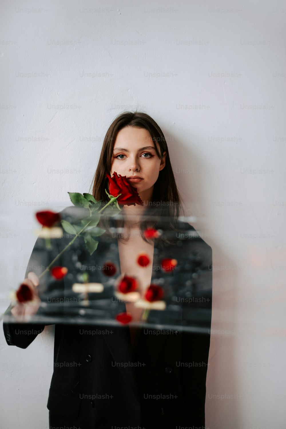 a woman holding a rose in front of her face