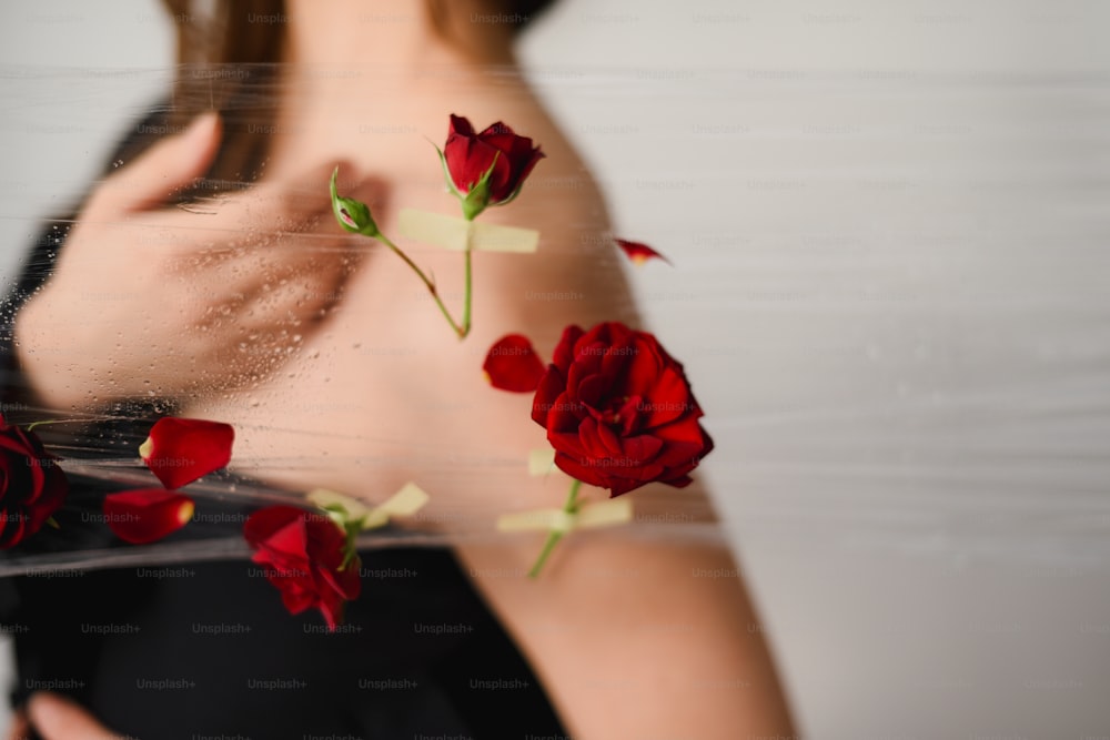 a woman holding a mirror with red roses on it