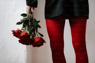 a person in tights holding a bouquet of roses