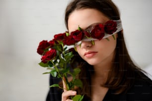 une femme tenant un bouquet de roses rouges