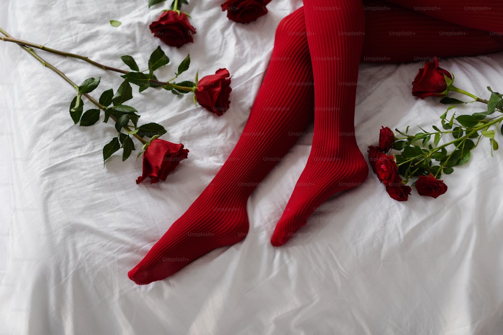 una mujer acostada en una cama con rosas rojas
