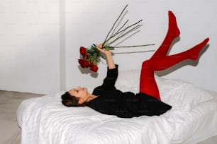 a woman laying on a bed with a bouquet of flowers