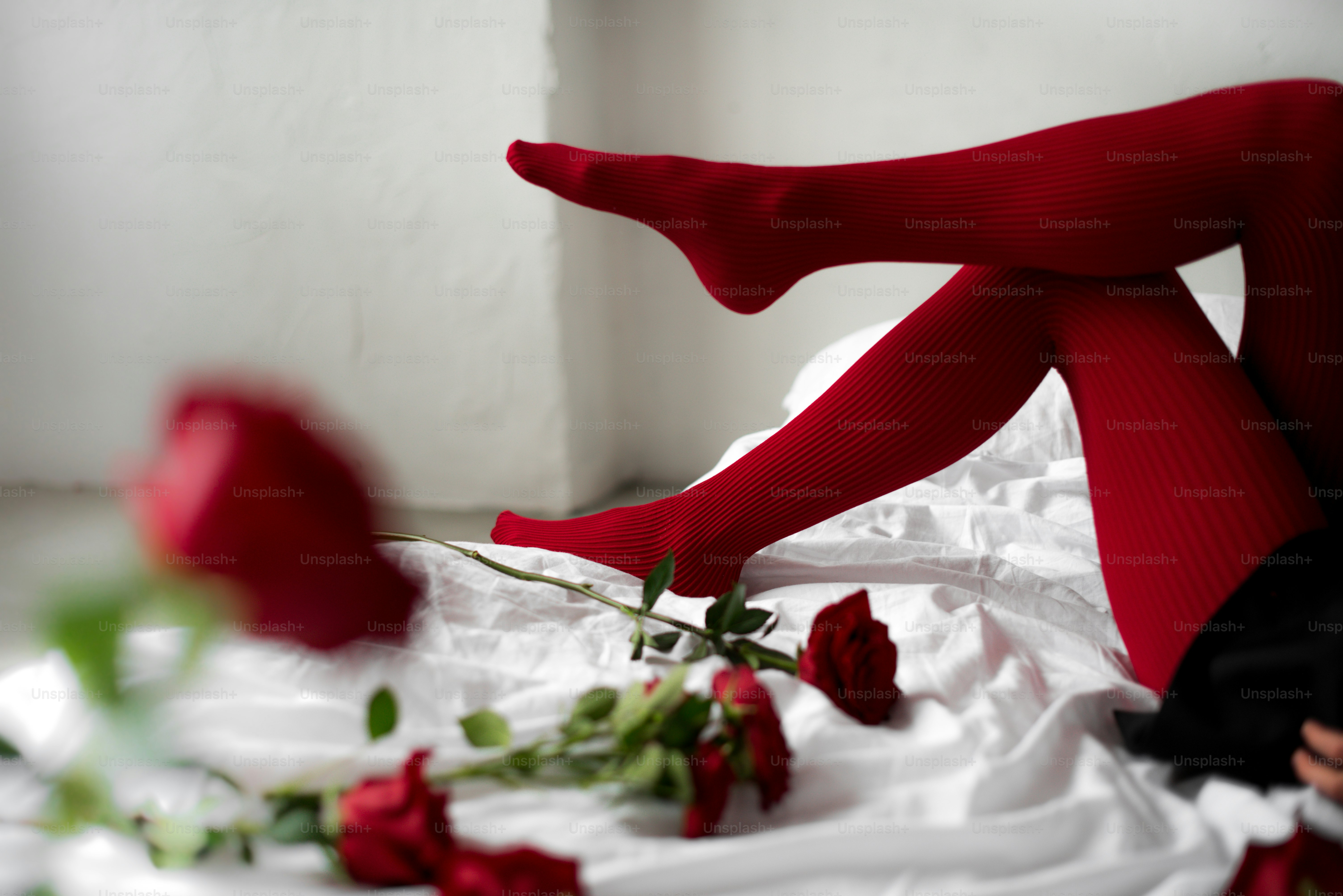 A woman laying on a bed with red roses photo – Flower Image on Unsplash