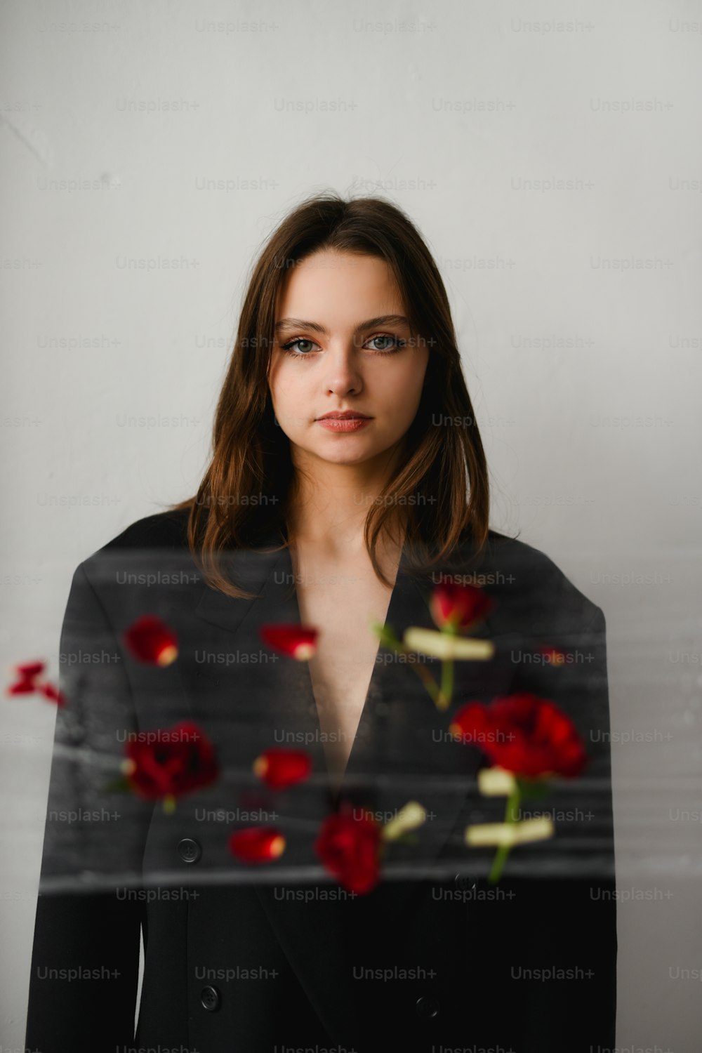 une femme en costume noir avec des roses rouges