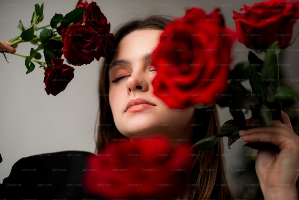 a woman holding a bunch of red roses