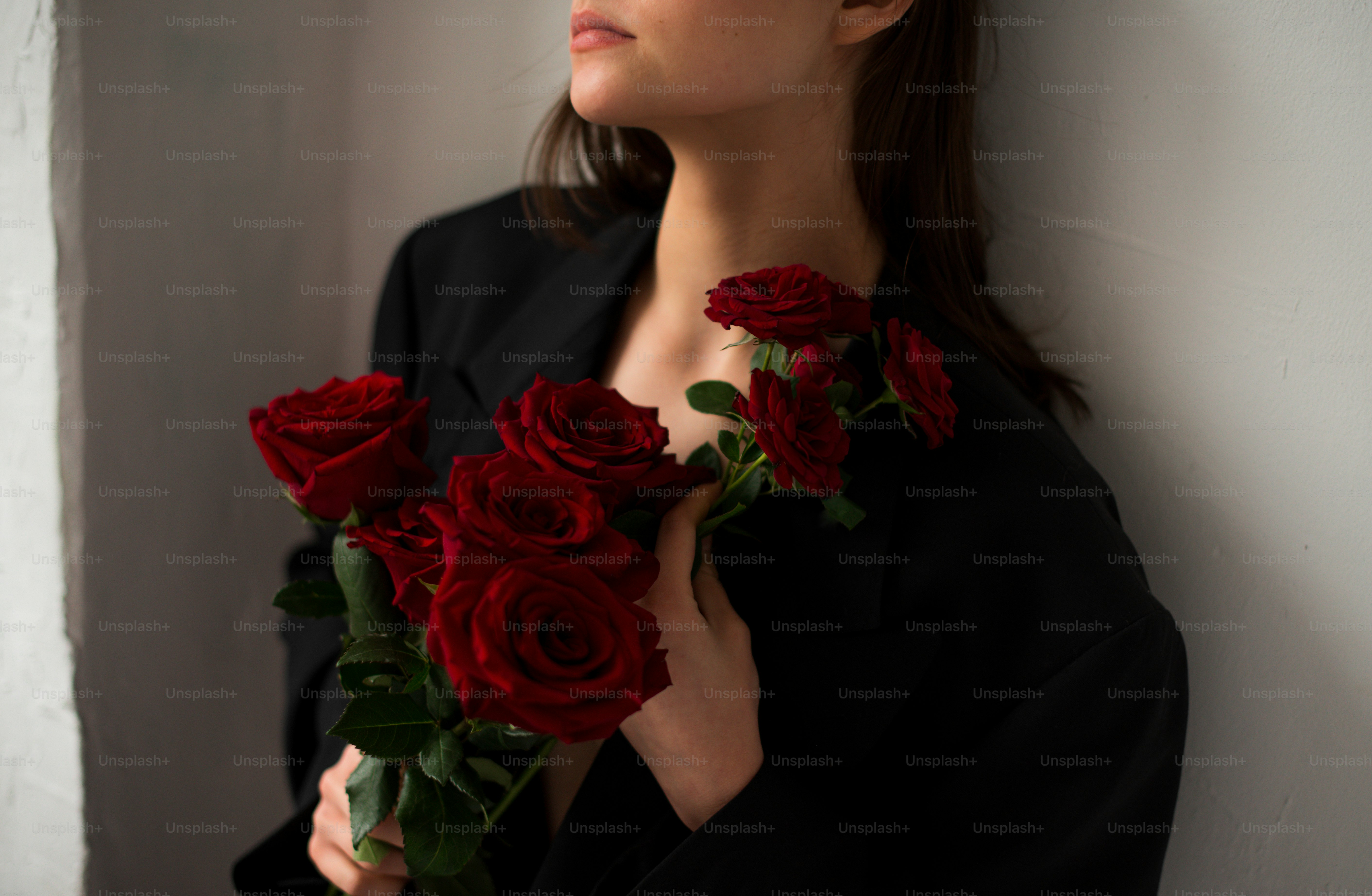 赤いバラの花束を持つ女性