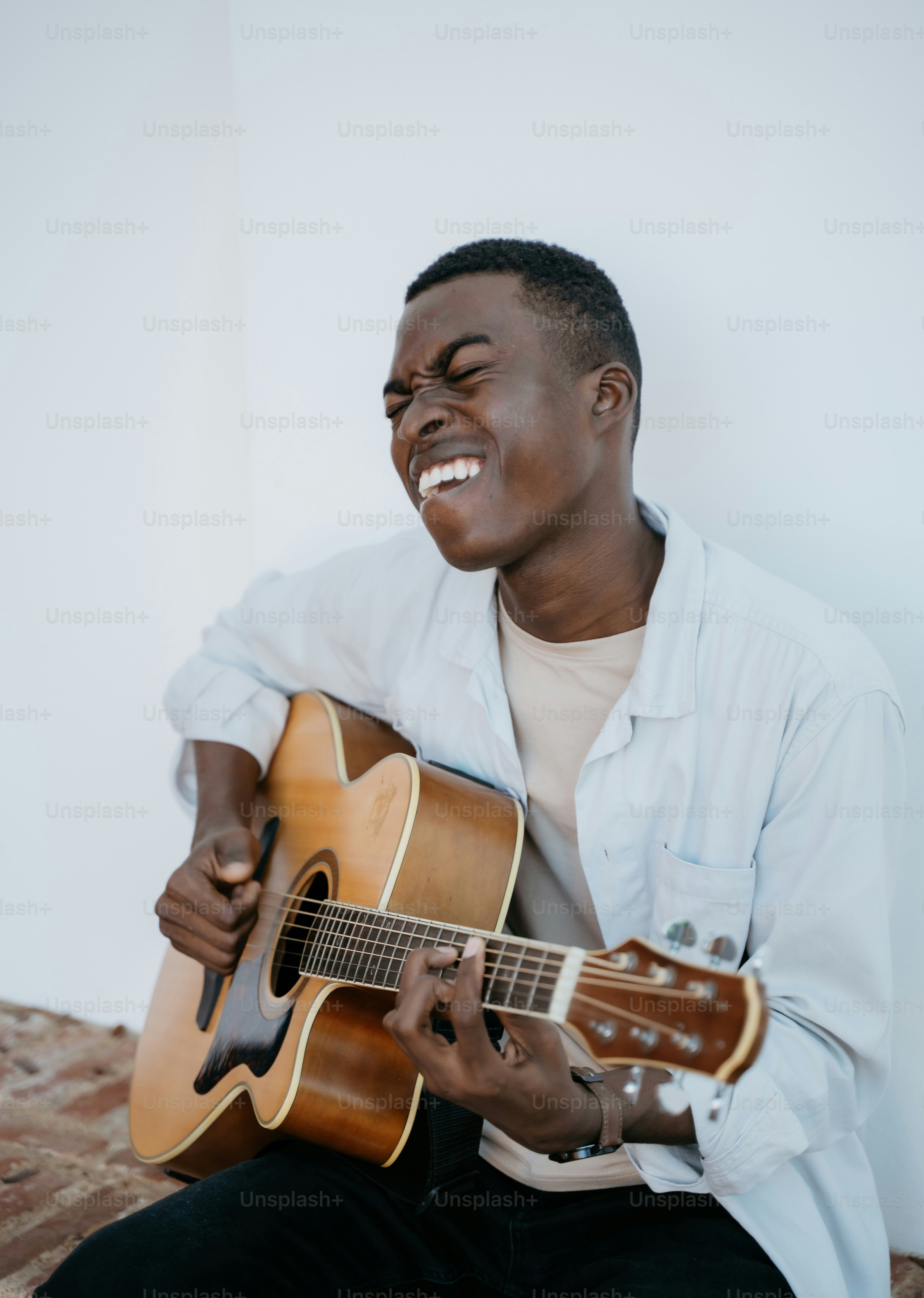 A man sitting on a bed playing a guitar photo – Music Image on Unsplash