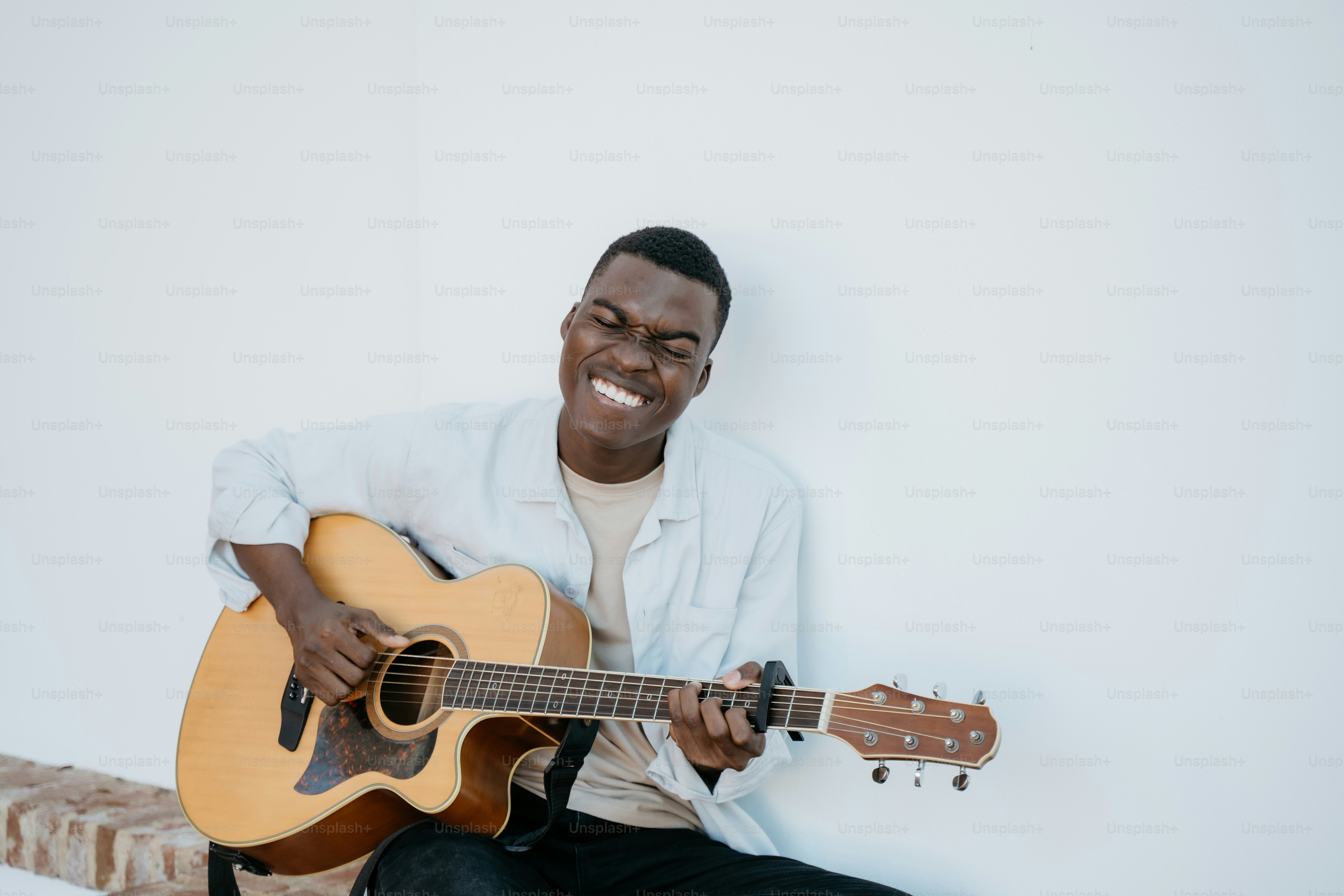 A man sitting on a bench playing a guitar photo – Music Image on Unsplash