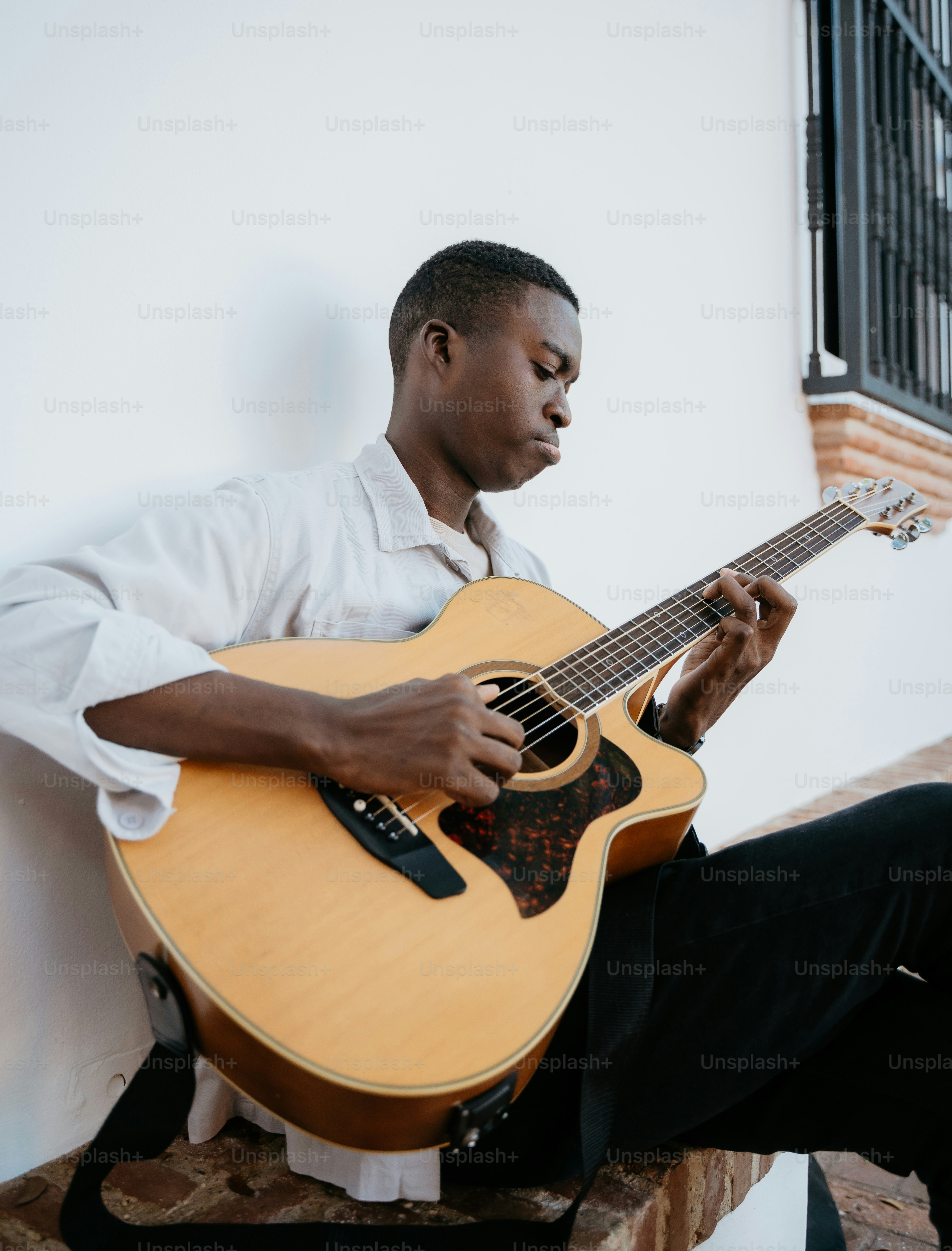 A man sitting on a bench playing a guitar photo – Music Image on Unsplash