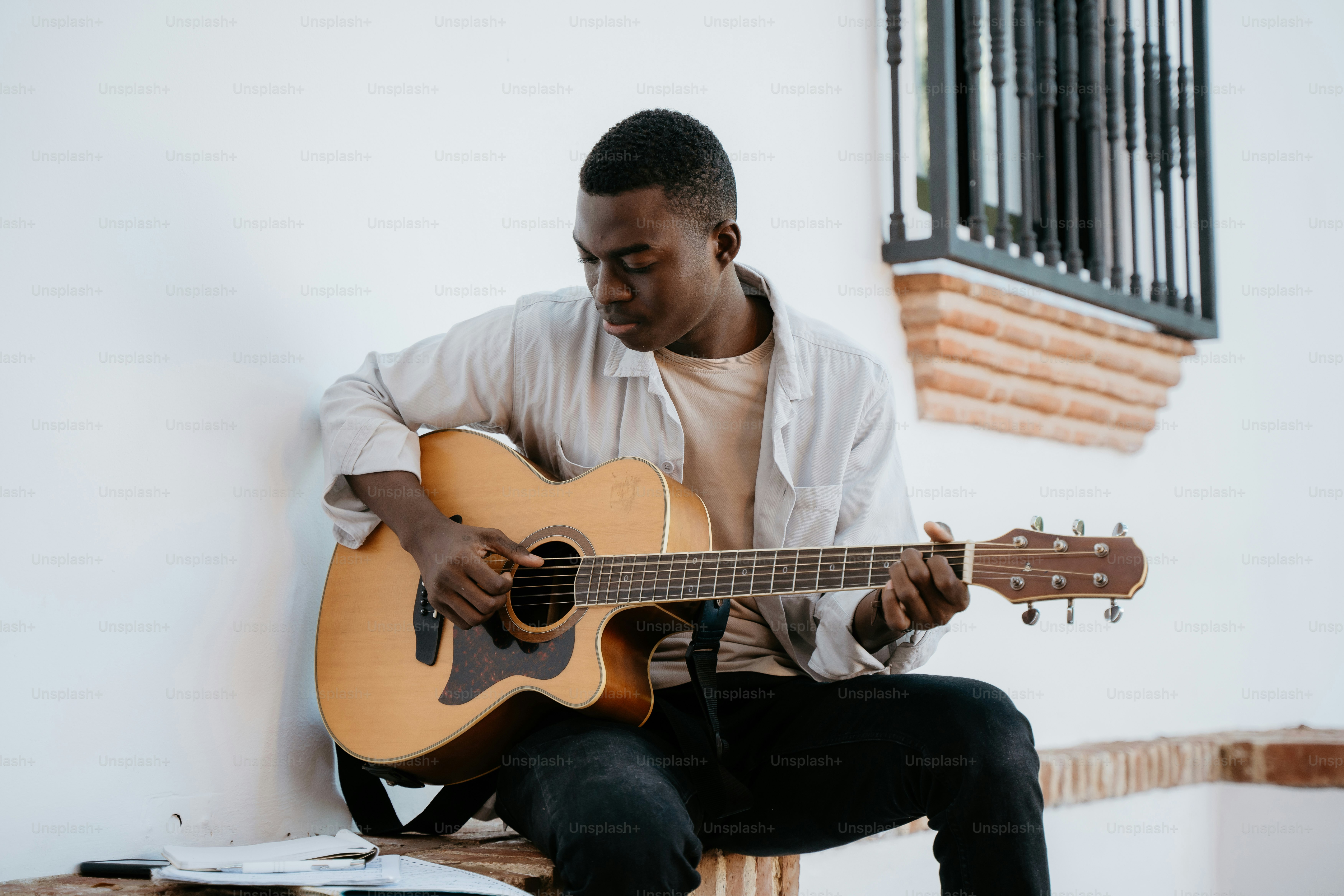 A man sitting on a bench playing a guitar photo – Music Image on Unsplash