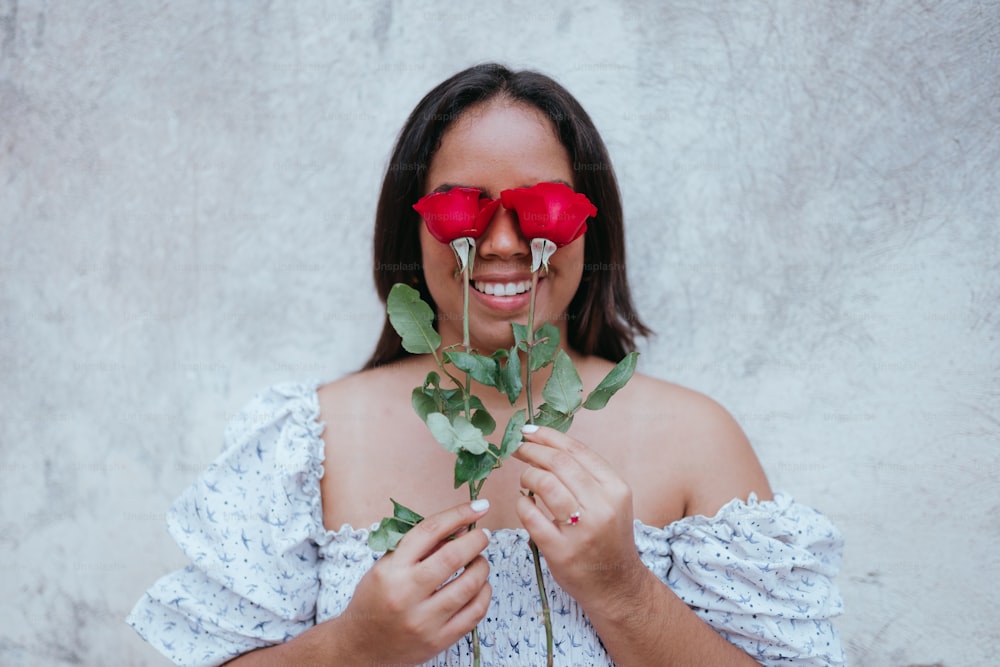 a woman wearing red glasses holding a rose