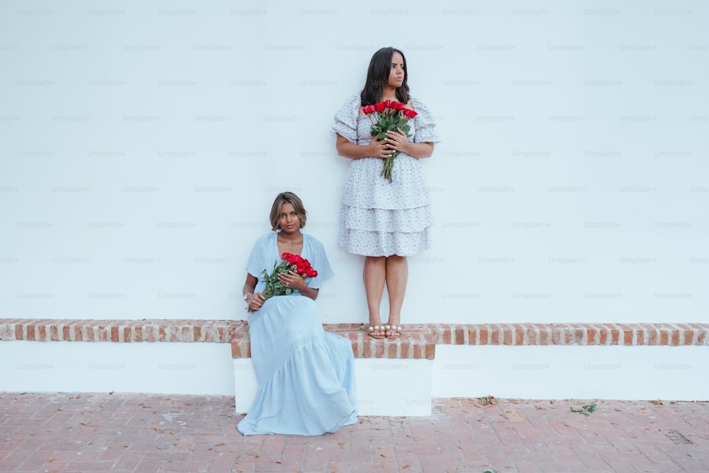 deux femmes debout l’une à côté de l’autre tenant des roses