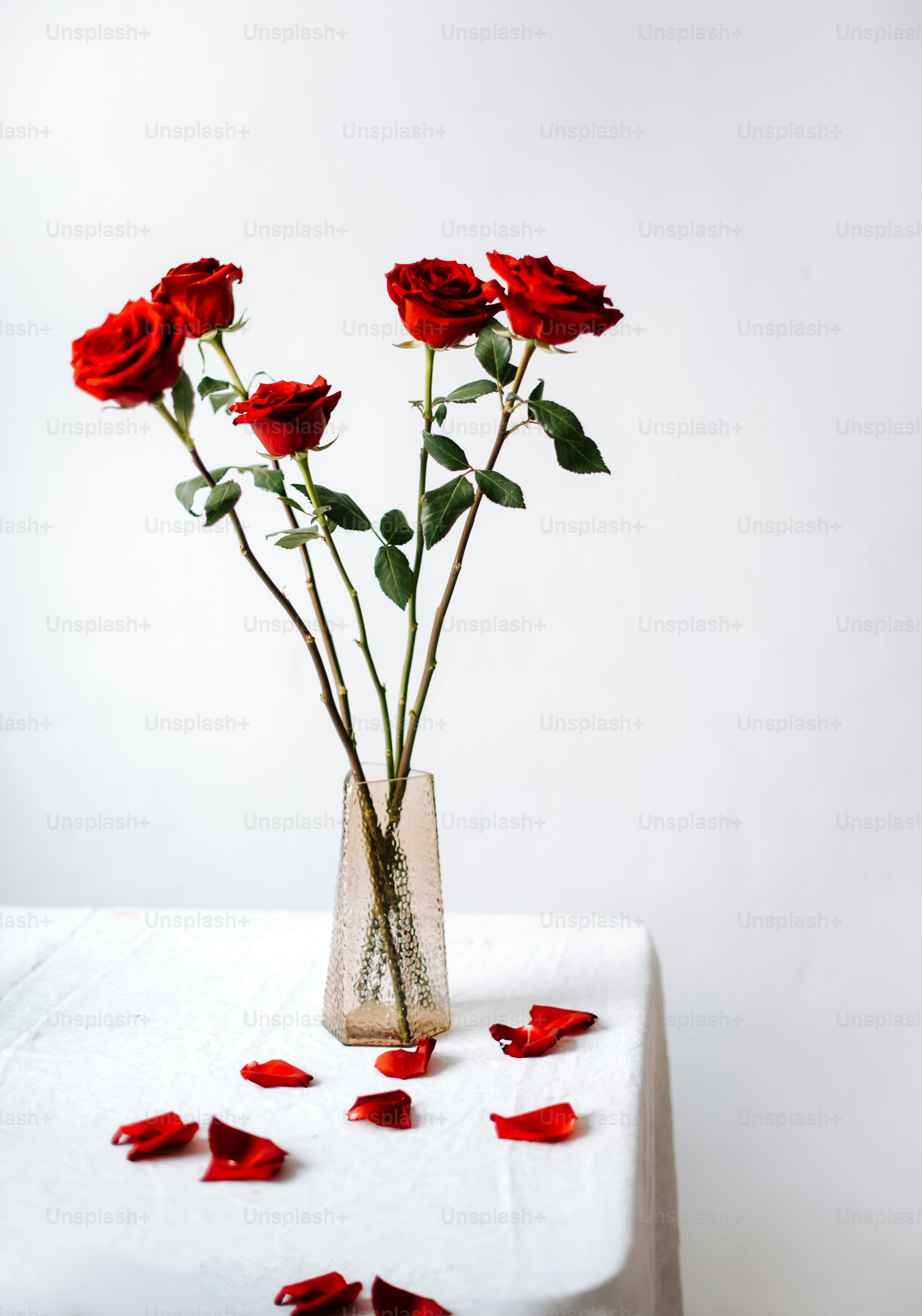a vase filled with red roses on top of a table