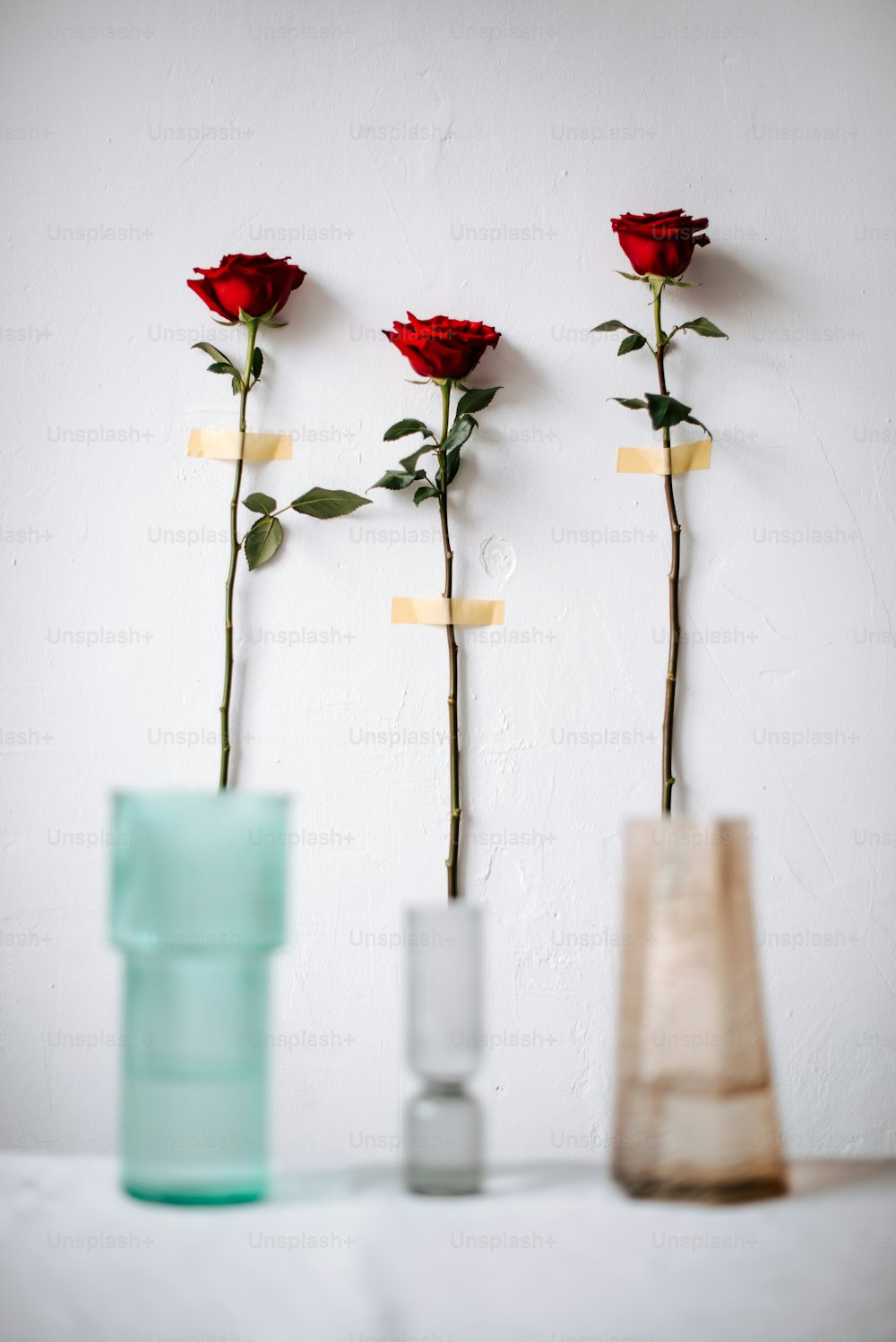 tres jarrones con rosas sobre una mesa