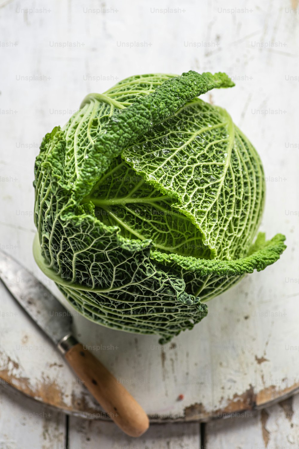 a head of cabbage sitting on top of a cutting board