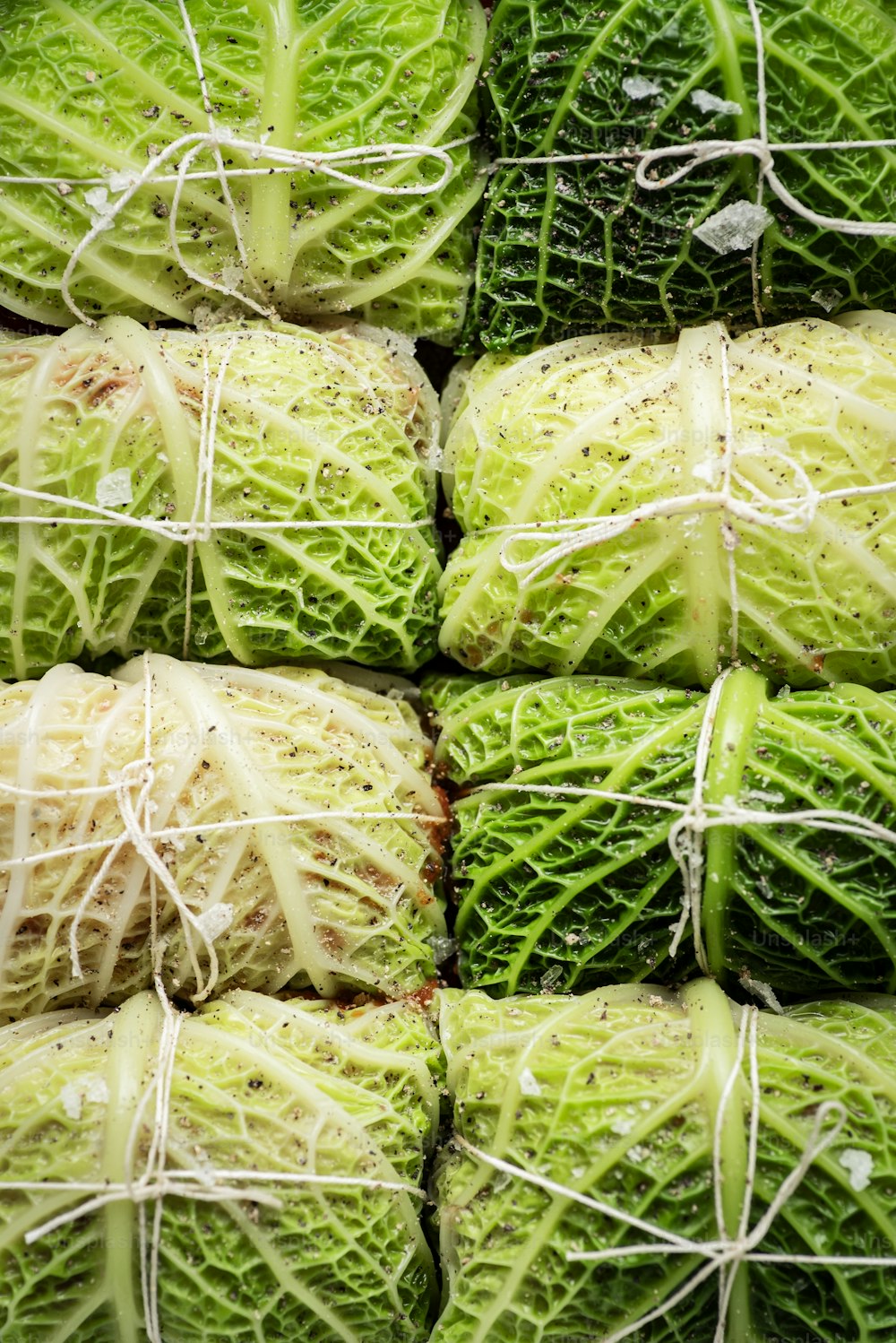 a pile of green cabbage wrapped in string