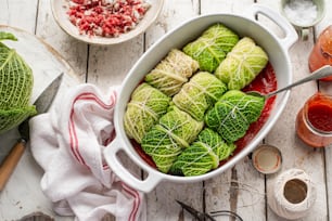 a white dish filled with cabbage covered in sauce