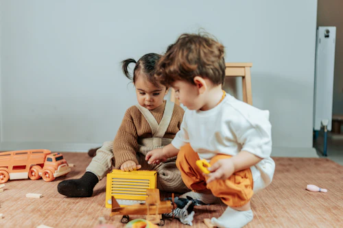 Deux tout-petits jouant ensemble avec des jouets colorés
