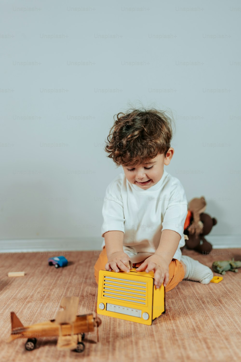 a toddler playing with a radio on the floor