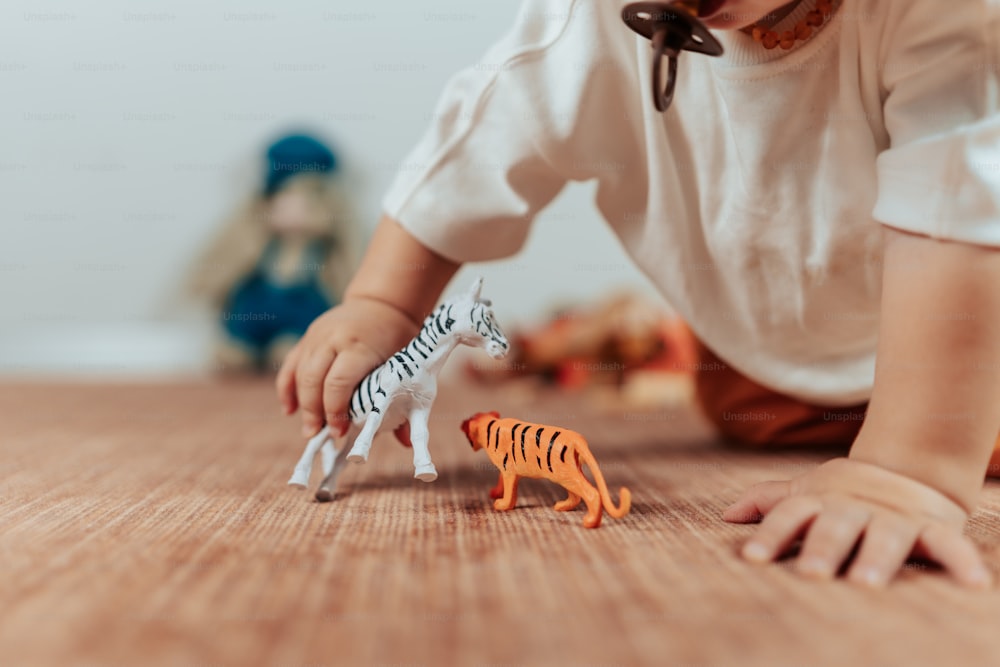 a little girl playing with a toy zebra