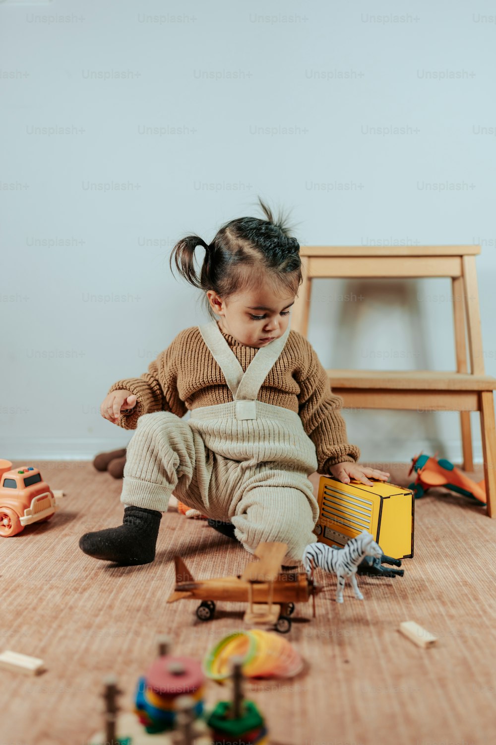 una bambina seduta sul pavimento che gioca con i giocattoli