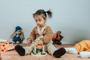 a little girl playing with toys on the floor