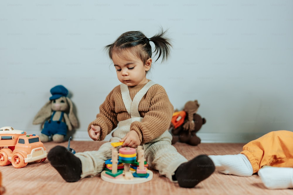 a little girl playing with toys on the floor