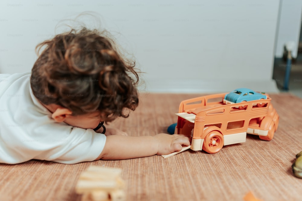 Un niño pequeño jugando con un camión de juguete