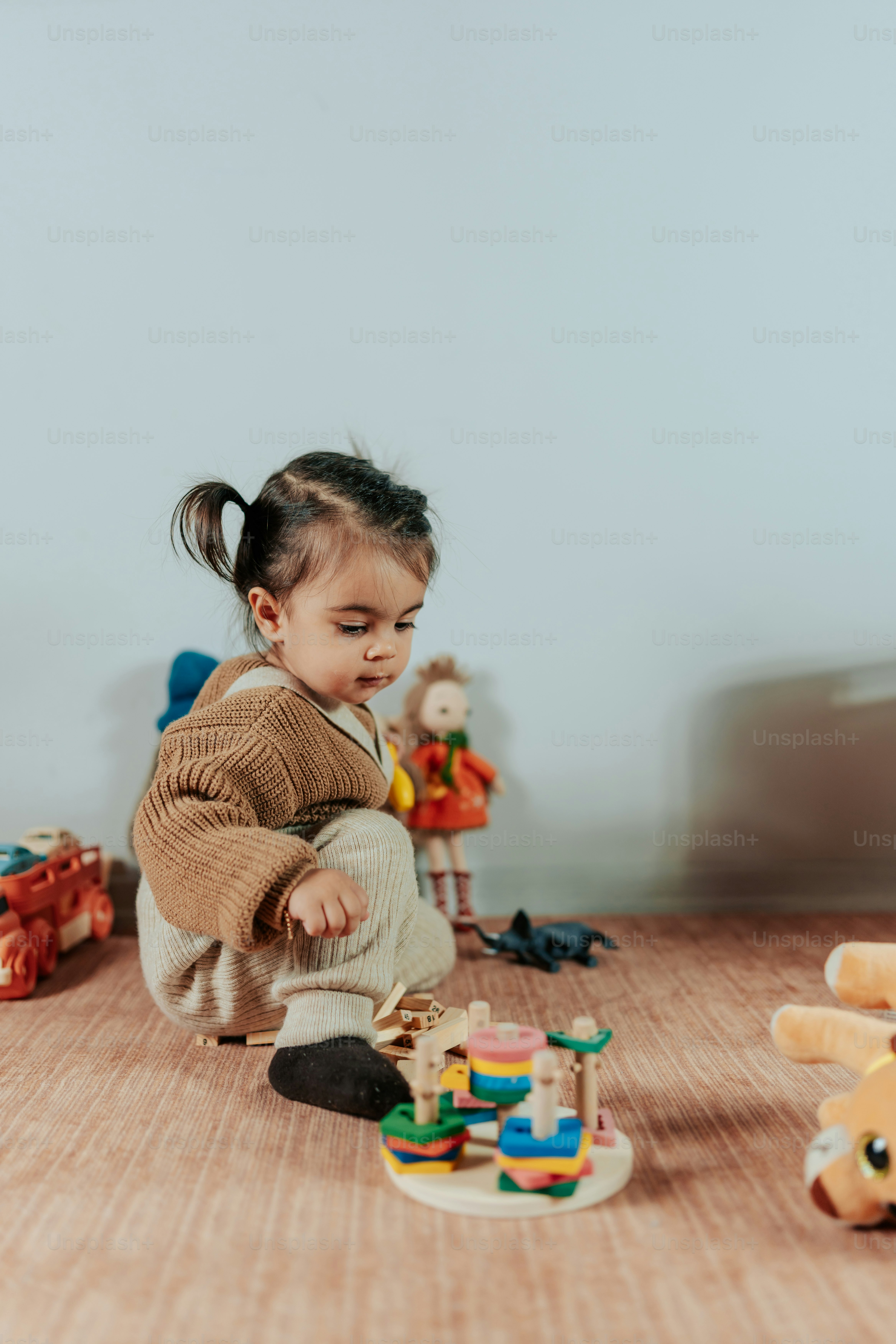 a little girl playing with toys on the floor
