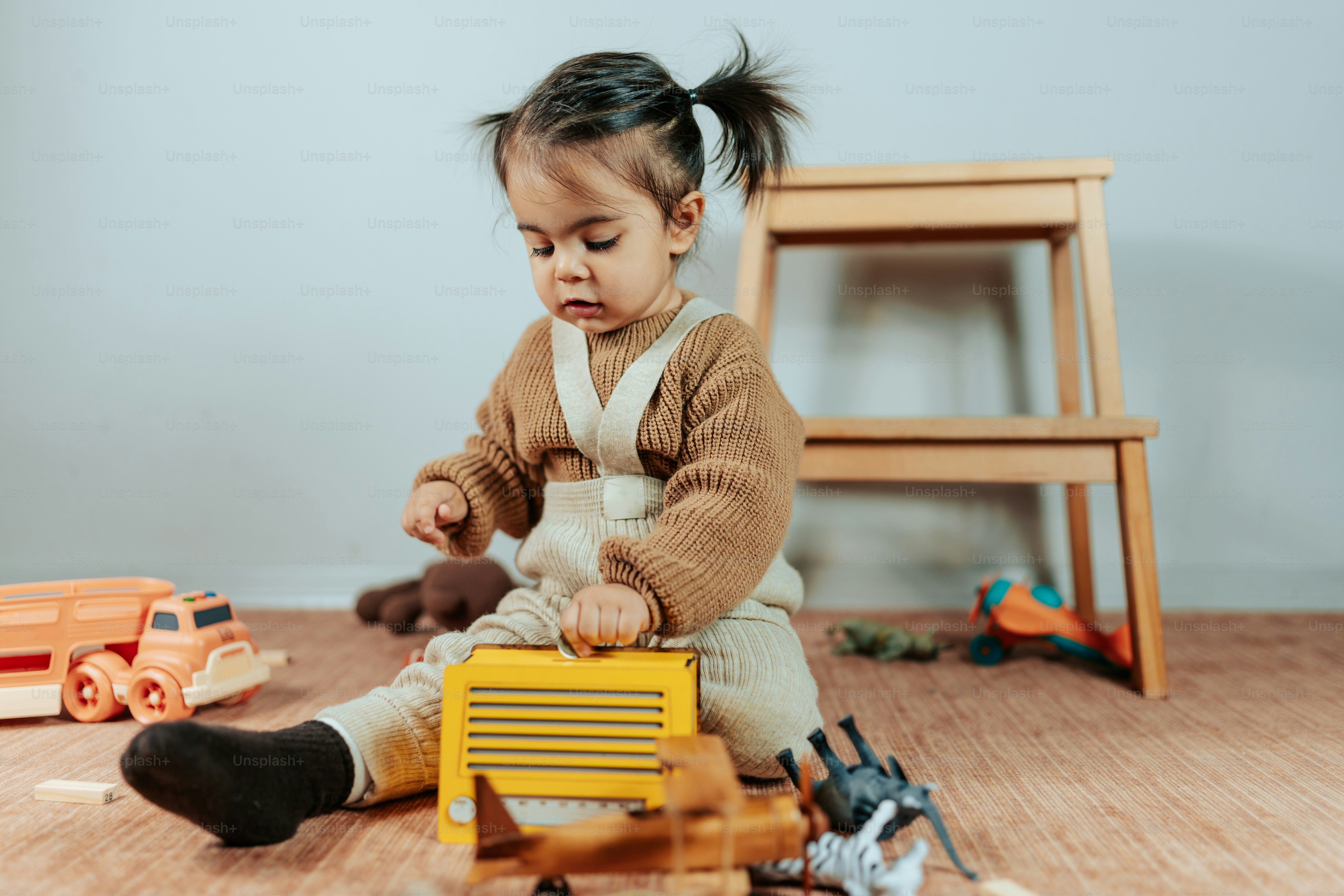 a little girl playing with toys on the floor