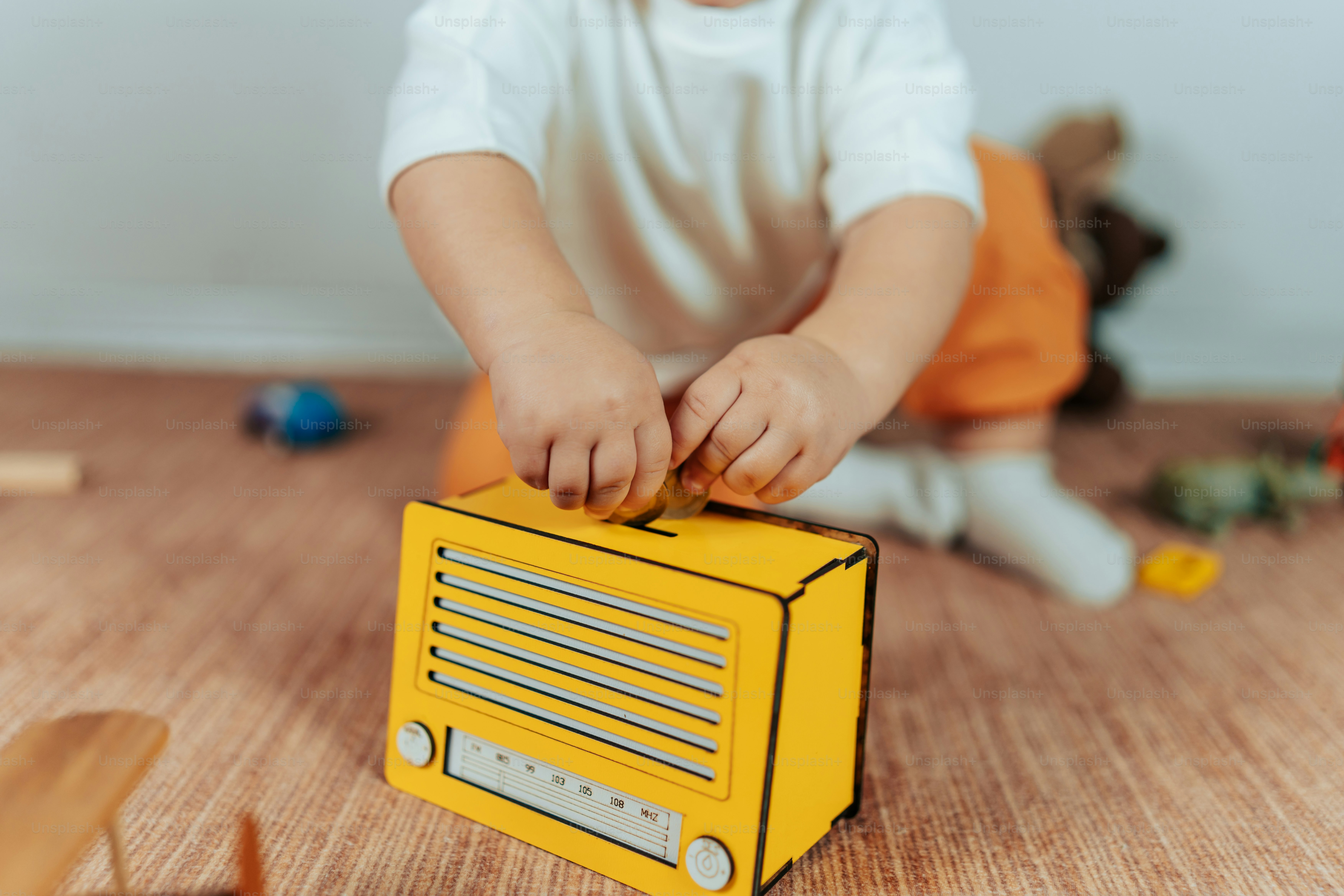 a small child playing with a radio on the floor