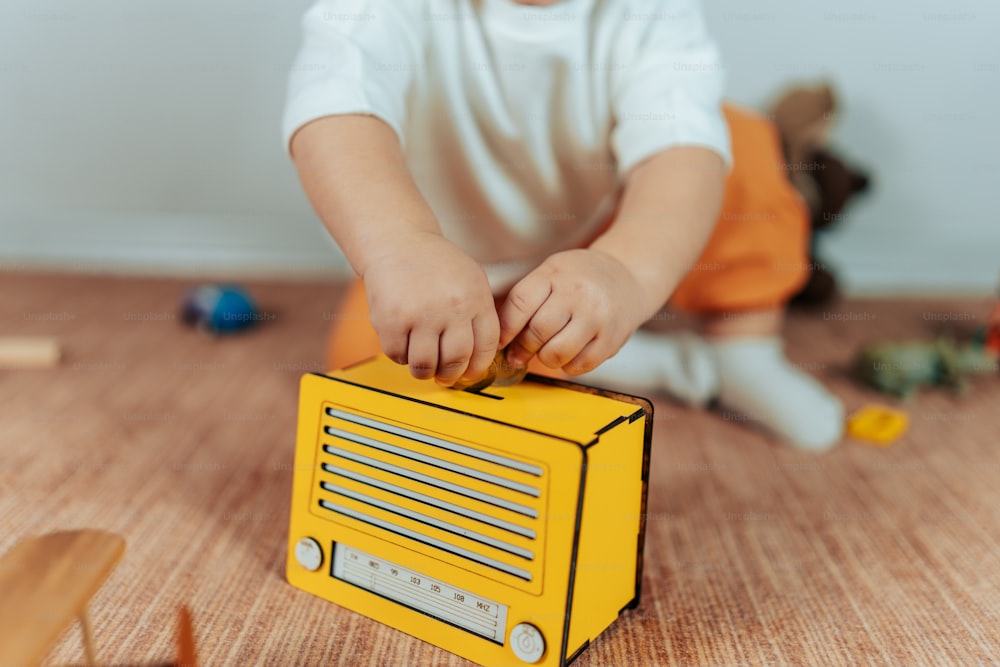 a small child playing with a radio on the floor