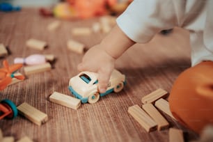 a child playing with wooden toys on the floor