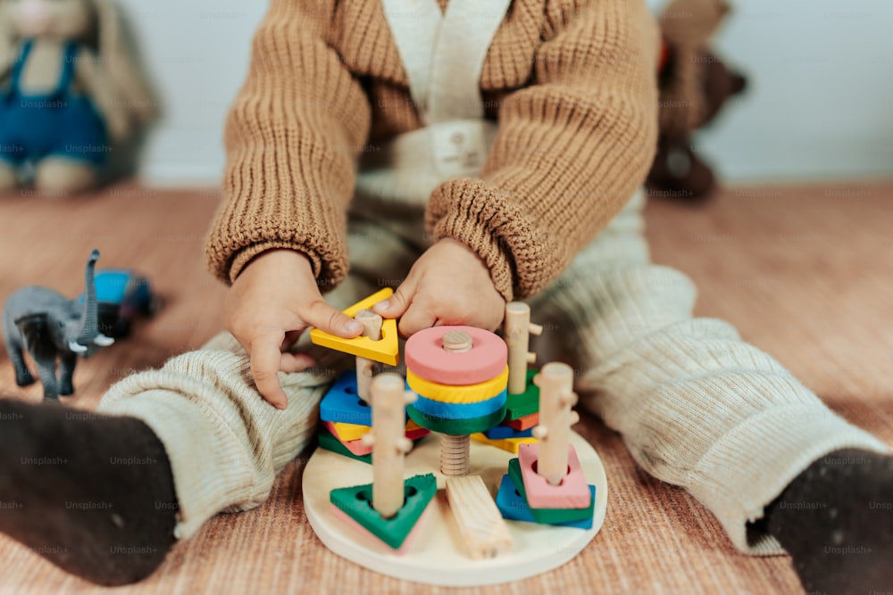 Un niño pequeño jugando con juguetes en el suelo