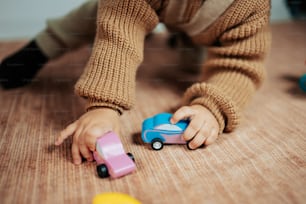 a child playing with a toy car on the floor