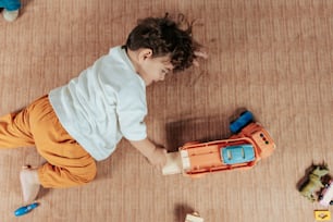 床の上でおもちゃで遊ぶ少年