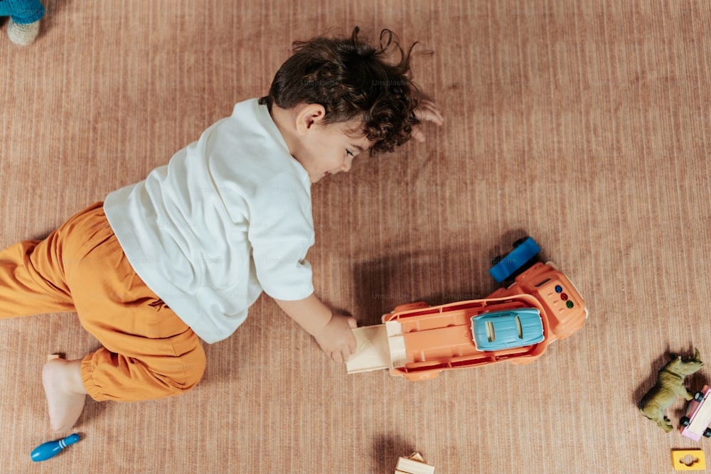 a young boy playing with toys on the floor