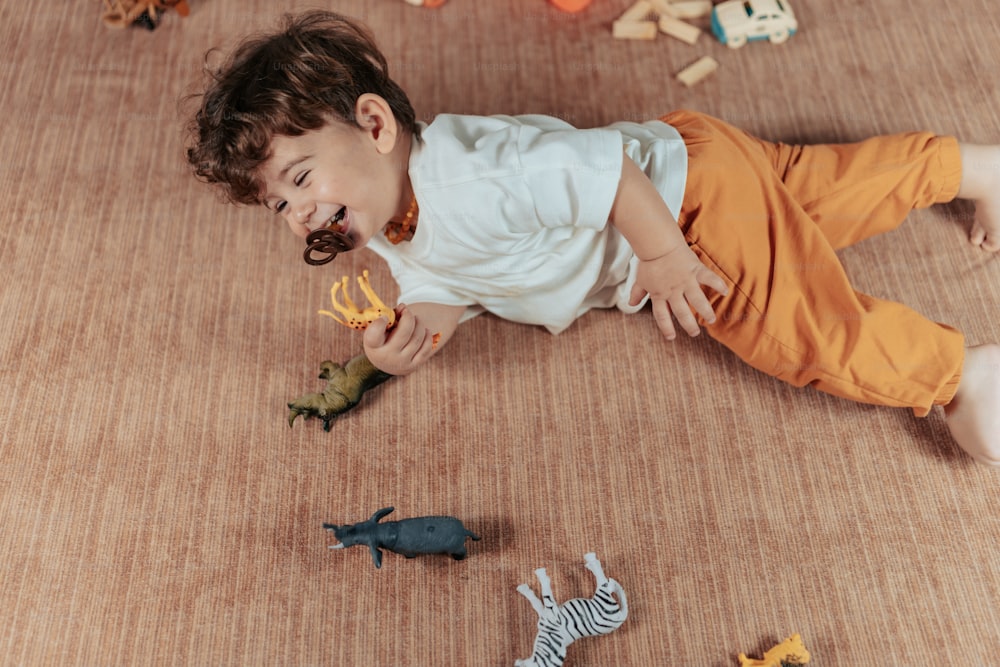un niño pequeño jugando con juguetes en el suelo