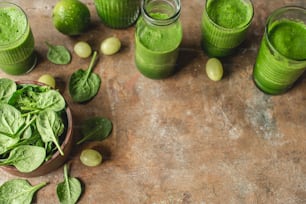 a wooden table topped with glasses filled with green drinks